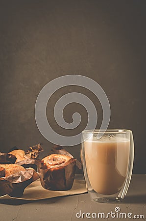 cakes with a chocolate stuffing on paper and cappuccino glass/cakes with a chocolate stuffing on paper and cappuccino glass on a Stock Photo