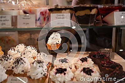 Cakes on display in patisserie shop window, Delicious pastries in coffee shop Stock Photo