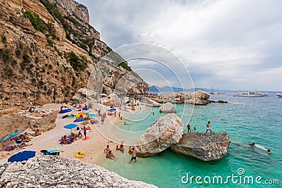 Beach in a natural cove in Sardinia in Italy. Numerous people on vacation during the Editorial Stock Photo