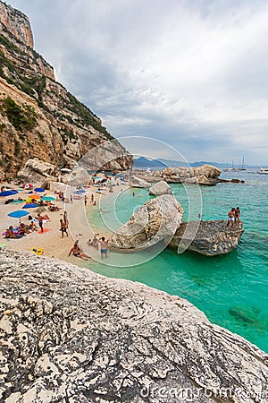 Beach in a natural cove in Sardinia in Italy. Numerous people on vacation during the Editorial Stock Photo