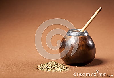 Calabash and bombilla with yerba mate isolated on brown Stock Photo