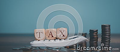 Calculate money for TAX with Calculator, wooden tax block, coins. Stock Photo