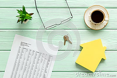 Calculate taxes for house with figure, keys, table, glasses and coffee on mint green wooden background top view Stock Photo