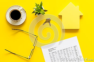 Calculate taxes for house with figure, keys, table, glasses and coffee on yellow background top view Stock Photo