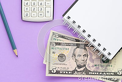 Calculator, notebook with american money and a pencil on a lilac background Stock Photo