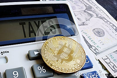 Calculator with word taxes and cryptocurrency coin. Crypto taxation. Stock Photo