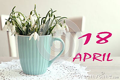 Calendar for April 18: the name of the month April in English, the numbers 18, a bouquet of snowdrops on the background of a Stock Photo