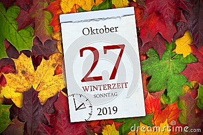 Calendar with autum leaves and the german words for wintertime and time change with return to standard time Stock Photo
