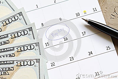 Calendar with blue marker circle in word payday and American dollars cash money for remind Stock Photo