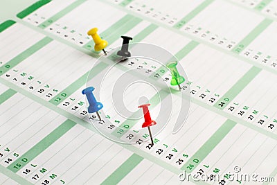 A daily calendar with colored pushpins marking some days Stock Photo
