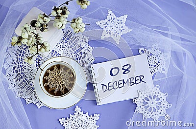 Calendar for December 8: a cup of tea with a decorative snowflake on a lace napkin, the name of the month December in English, Stock Photo