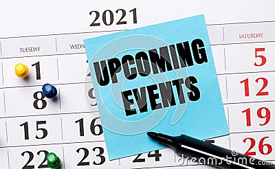 The calendar has a blue sticker with the text UPCOMING EVENTS and a black marker. Organizational concept. View from above Stock Photo