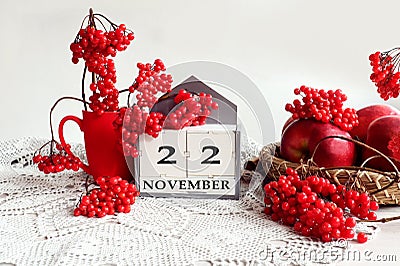 Calendar for November 22: the name of the month in English, the number 22, a bouquet of viburnum and viburnum branches, apples on Stock Photo