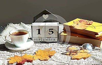 Calendar for September 15 : the name of the month in English, cubes with the number 15, a cup of tea, books, maple leaves on a Stock Photo