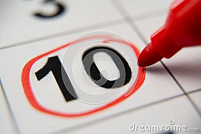 The calendar 10th day of the month is circled. A red marker circles the tenth day of the month from the paper calendar Stock Photo