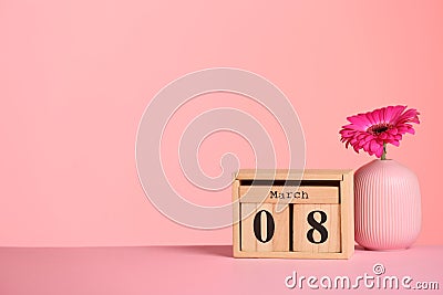 Calendar and vase with flower on table against color background, space for text. Stock Photo