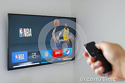 A person using an apple tv remote using the NBA application. Concept watching American Editorial Stock Photo