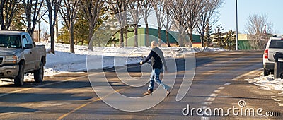 A pedestrian Jaywalking a road during winter season. Jaywalking is Walking in or crossing Editorial Stock Photo