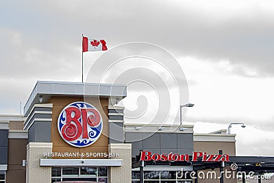 A Boston Pizza restaurant sign with a Canadian Flag. Boston Pizza International Adds Five New Editorial Stock Photo