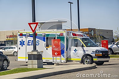 An EMS Ambulance parked in front of a McDonalds Editorial Stock Photo