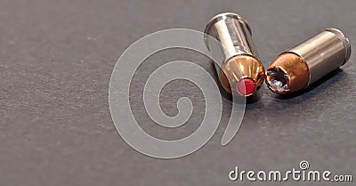 A 40 caliber hollow point bullet and a 44spl red tipped bullet laying together Stock Photo