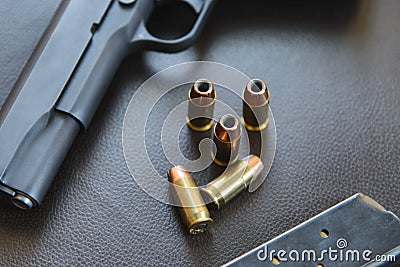 .45 Caliber hollow point bullets near handgun and magazine on le Stock Photo