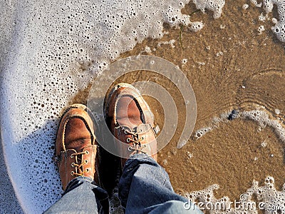 California beach shot of my boots with the sea foam lapping at my feet. For travel blogs as a banner image, graphic, social media Stock Photo