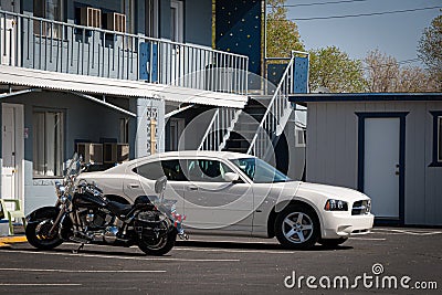 California, USA. May 2010: Harley Davidson bike and Fod mustang parked outside a road Motel Editorial Stock Photo