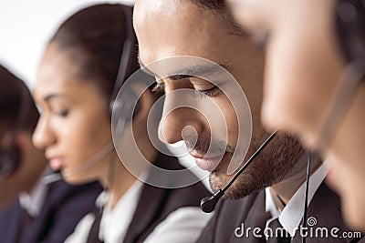 Call center operators in headsets working together Stock Photo