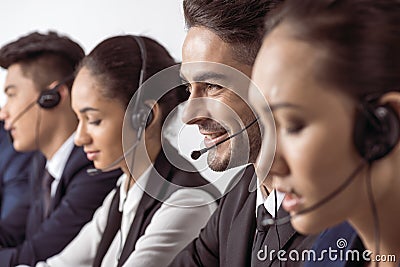 Call center operators in headsets working together Stock Photo