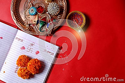 Calligraphy writing in hindi Shubha Labh means Goodness & Wealth, over Red accounting note book , diya, Stock Photo