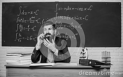 Calling parents. School teacher call mobile phone while sit classroom chalkboard background. Teacher bearded man talk Stock Photo