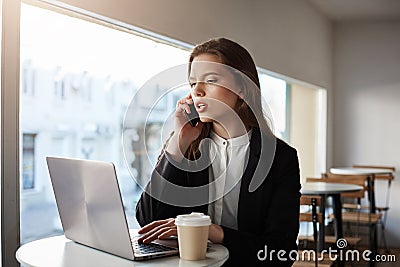 Calling you to inform about stage of work. Indoor shot of serious and focused successful businesswoman in trendy outfit Stock Photo