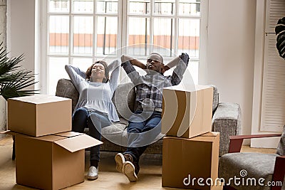 Calm African American couple relaxing leaning back on couch Stock Photo