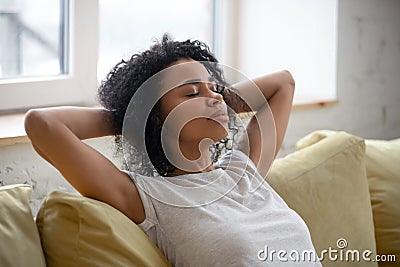 Calm african american woman with hands behind head relaxing. Stock Photo