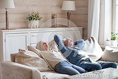 Calm aged couple sleeping on couch relaxing at home Stock Photo