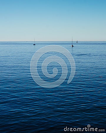 Calm Blue Pacific Ocean and Lazy Sailboats Stock Photo