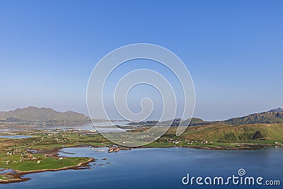 Calm blue waters wind through green areas and small villages in Norway's peaceful Lofoten Stock Photo