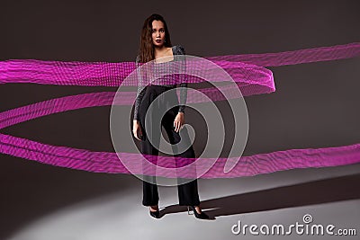 calm caucasian lady in blouse and black trousers posing at camera on freeze light coloured space Stock Photo