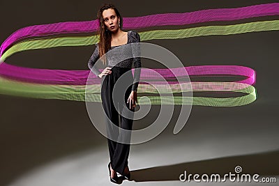 calm caucasian lady in blouse and black trousers posing at camera on freeze light coloured space Stock Photo