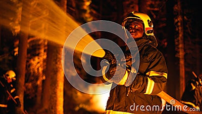 Calm and Collected African American Firefighter Extinguishing a Wildland Fire Deep in a Forest Stock Photo