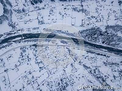 Calm and cosy fairy-tale village Kryvorivnia covered with snow in the Carpathians mountains, aerial view. Typical landscape in Stock Photo