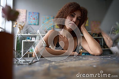Calm curly woman feeling pensive at florist studio Stock Photo