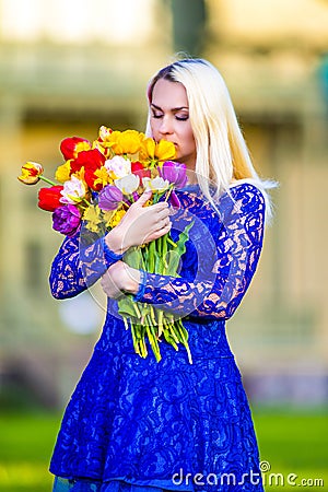 Calm Dreaming Caucasian Blond Smelling Bunch of Tulips Stock Photo