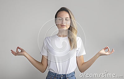 My body is fortress. Calm fashionable young european woman with blonde hair, standing with closed eyes and relaxed expression, Stock Photo