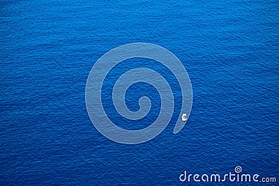 Calm flat surface of ocean and small fisher boat. Mediterranean Sea. Stock Photo