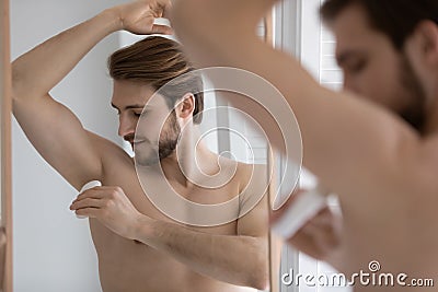 Calm handsome young well built man using deodorant Stock Photo