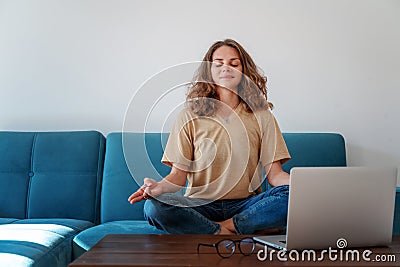 Calm healthy young woman taking break with eyes closed sit on blue sofa with laptop, breathing exercise at home feel stress, Stock Photo