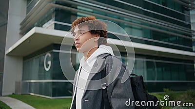 Calm hipster walking downtown closeup. Young man moving street looking distance Stock Photo