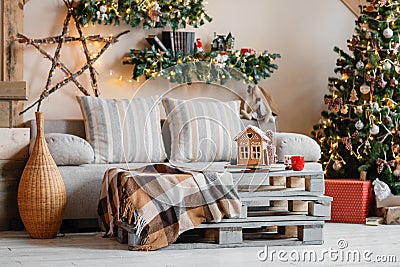 Calm image of interior modern home living room decorated christmas tree and gifts, sofa, table covered with blanket. Stock Photo